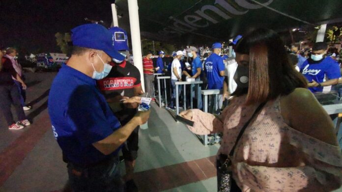 Fanáticos acuden al estadio Quisqueya con tarjeta vacuna en mano Fanáticos acuden al estadio Quisqueya con tarjeta vacuna en mano