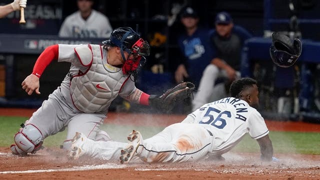 El cubano Randy Arozarena (56), de los Rays de Tampa Bay, se roba el plato de barrida frente al receptor puertorriqueño Christian Vázquez, de los Medias Rojas de Boston, en la séptima entrada del primer partido de la Serie Divisional de la Liga Americana en San Petersburgo, Florida. El bateo explosivo de los cubanos ayudaron al triunfo. (AP Foto / Steve Helber)