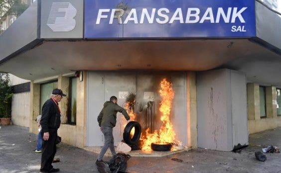 Manifestantes queman bancos en protesta por la caida de la
