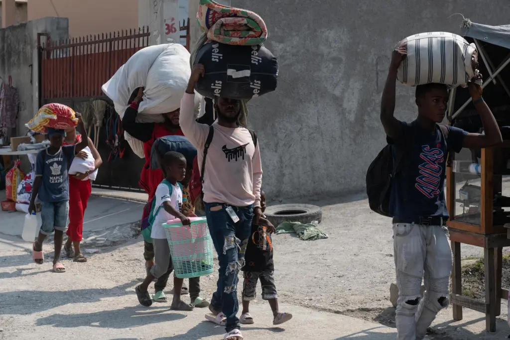 Personas abandonan sus hogares a causa de la guerra entre bandas armadas en la zona de Pernier, en la comuna de Petionville, hoy en Puerto Príncipe (Haití). EFE/Johnson Sabin
