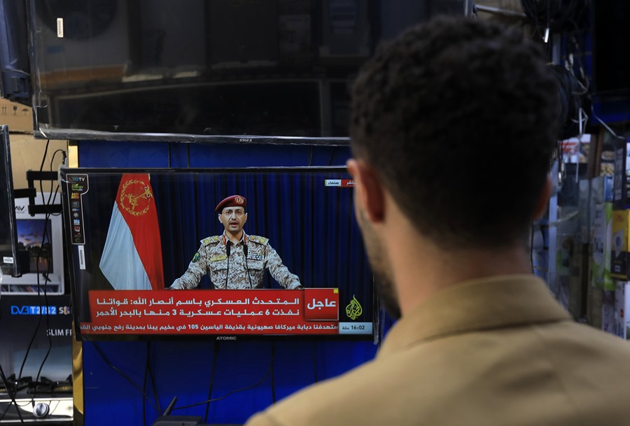 Un hombre sigue por televisión en Saná la declaración del portavoz militar hutí, Yahya Sarea, sobre nuevos ataques marítimos