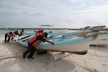 Pescadores arrastran un bote fuera del agua para resguardarlo de la llegada del huracán Milton en Progreso, México (REUTERS/Lorenzo Hernandez)