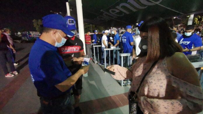 Fanáticos acuden al estadio Quisqueya con tarjeta vacuna en mano