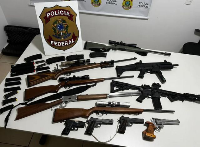 Rifles, pistolas e fusiles sobre mesa