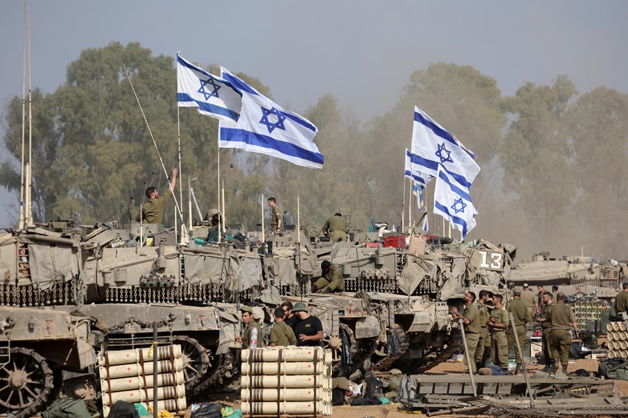 Soldados israelíes con sus tanques se reúnen en una posición cerca de la frontera con la Franja de Gaza