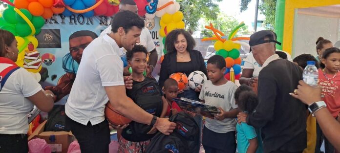 Jugador de la NFL Bayron Matos y Raymond Rodríguez entregan útiles escolares y juguetes en Los Mina