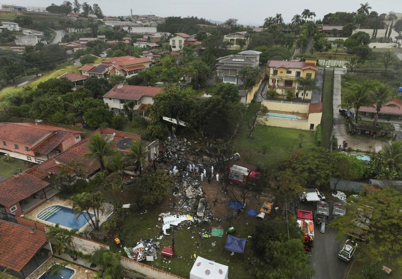 Bomberos y equipos de rescate trabajan en el lugar de una zona residencial donde se estrelló un avión con 62 personas a bordo en Vinhedo, estado de Sao Paulo, Brasil.