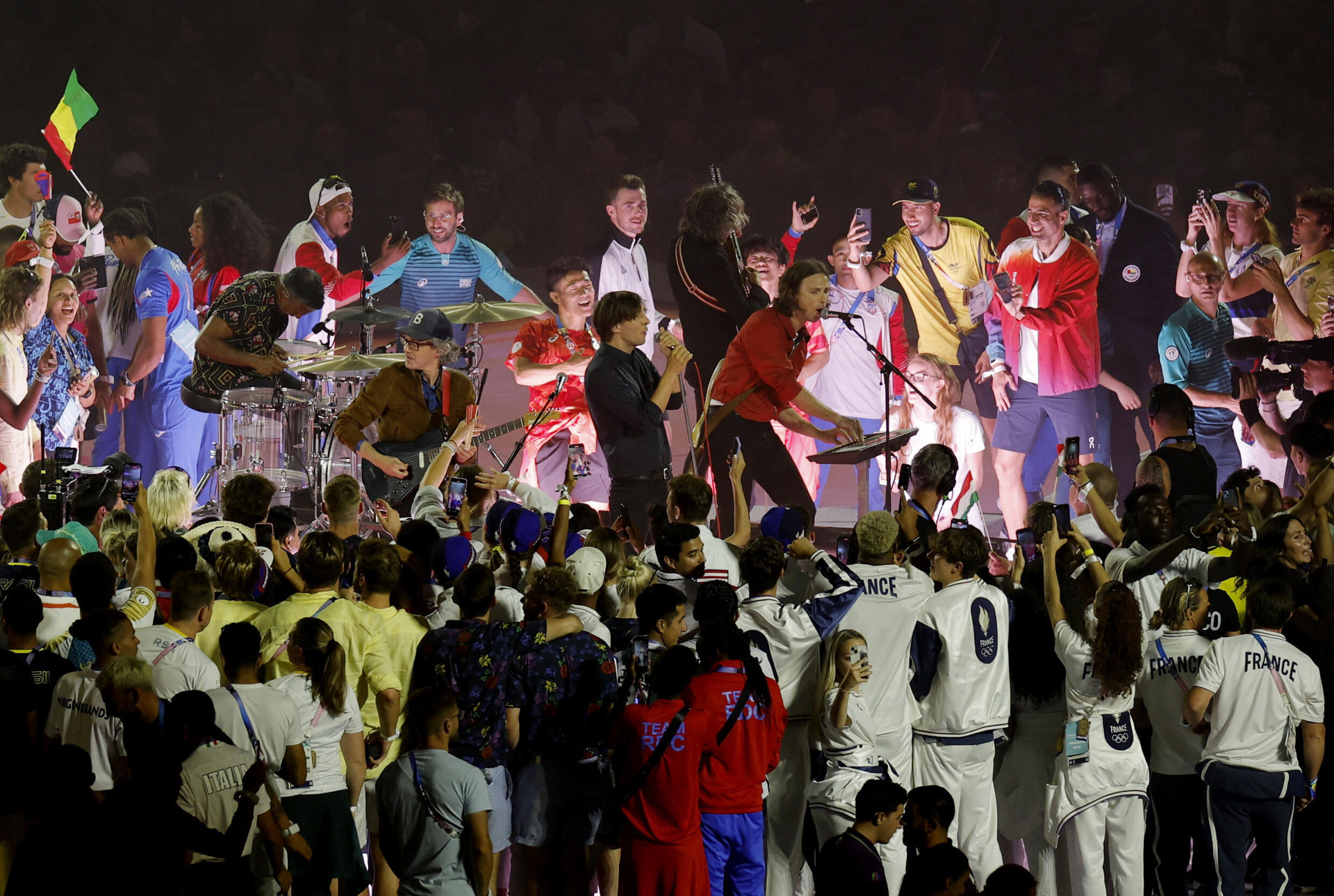 Los atletas rodean el escenario mientras se presenta el grupo francés Phoenix. REUTERS/Anushree Fadnavis